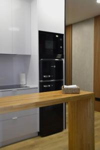 a kitchen with a black refrigerator and a counter at Nómada Orzán bajo in A Coruña +7 photos