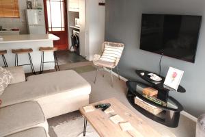 a living room with a couch and a table at Stylish Apartment in Hermanus in Hermanus