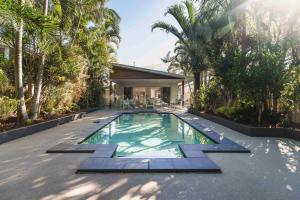 a swimming pool in a backyard with palm trees at Golden Beach Oasis - Sleeps 12 in Golden Beach