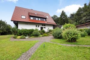 a white house with a red roof and a yard at Haus am Alpenblick Rothaus in Grafenhausen