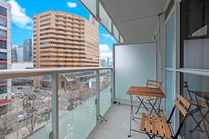 a balcony with a table and chairs on a building at Classy 1-Bedroom & Den Condo in Heart of Downtown in Toronto
