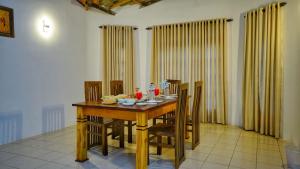 a dining room with a wooden table and chairs at Temple Entrance Villa in Dambulla
