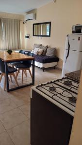 a kitchen and living room with a table and a couch at Once Reinas Departamentos in San Rafael +35 photos