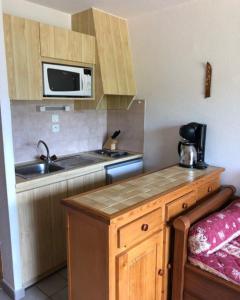 a small kitchen with a sink and a microwave at Studio au pied des pistes - Vue montagne in Saint-Jean-dʼAulps