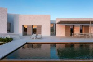a house with a swimming pool in front of it at MedBlu Paros in Paros National Airport