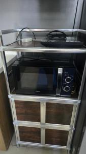 a microwave sitting on a shelf in a kitchen at Studio With Citylights and SEAview near MALL inside IT PARK in Sampong