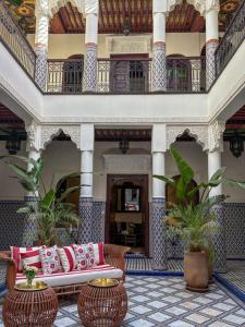 un hall d'un immeuble avec un canapé et deux tables dans l'établissement Riad Yakimour, à Marrakech