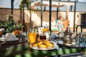 une table avec deux assiettes de nourriture et de jus d'orange dans l'établissement Riad Yakimour, à Marrakech 37 autres photos