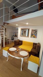 a living room with a yellow couch and a table at Pécs Inn in Pécs