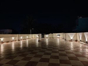 a checkerboard tile floor with lights on it at night at THE VILLA Pondicherry in Puducherry