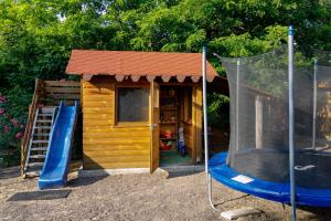 a small wooden play house with a slide at Rózsa-Domb Vendégház in Golop