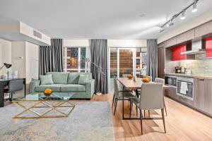 a living room with a green couch and a table at Classy 1-Bedroom & Den Condo in Heart of Downtown in Toronto
