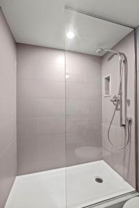 a shower with a glass door in a bathroom at Classy 1-Bedroom & Den Condo in Heart of Downtown in Toronto +16 photos