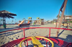 un parque infantil en la playa con tobogán y columpios en Blue Marine Village en Rodi Garganico