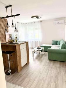 a living room with a green couch and a table at Bella LUX in Modriča