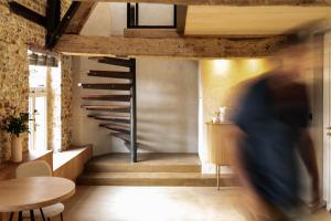a person walking past a staircase in a room at Boutique Suite Hotel Bolt21 Maastricht in Berg en Terblijt
