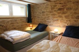 a bedroom with two beds and a window at Gîte tout confort Les Champs de la Goutte à Moussey, au calme au cœur des Vosges in Moussey