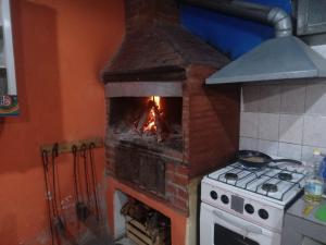 a brick oven with a fire in it in a kitchen at Posada del Valle in San Agustín de Valle Fértil