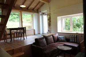 a living room with a couch and a table at Gîte tout confort Les Champs de la Goutte à Moussey, au calme au cœur des Vosges in Moussey