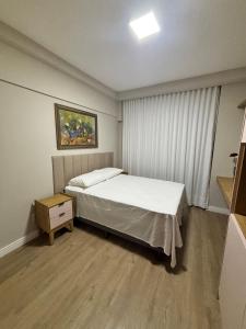 Un dormitorio pequeño con una cama y una mesita de noche. en Apartamento Mobiliado Belém COP30, en Belém