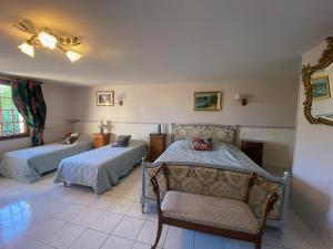 a room with two beds and a couch and a chair at Chambres d'Hôtes Lambert Rouen in Saint-Jean-du-Cardonnay