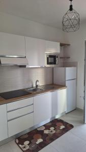 a white kitchen with a sink and a microwave at FlyWish - Salerno Costa d'Amalfi Airport in Salerno Airport - Aeroporto di Salerno +6 photos