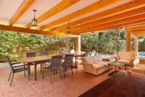 Un patio con una pérgola de madera con mesa y sillas. en La Gola, en La Manga del Mar Menor