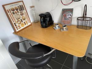 a wooden table with a black chair at a desk at Dépendance de Maison in Saint-Genis-Laval