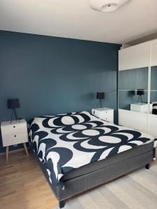 a bedroom with a black and white bed and blue walls at City center apartment in Rovaniemi