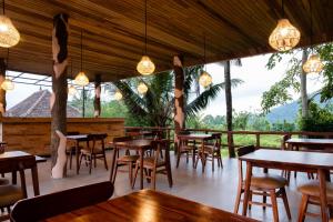 a restaurant with tables and chairs and windows at Cassowary Villas Sidemen by AGATA in Sidemen