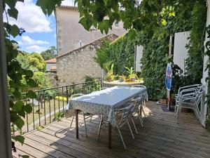 a table and chairs on a wooden deck at Pause ton sac in Condom