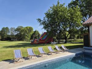 Un grupo de sillas junto a una piscina con un tobogán. en Lubie Apartments Lubieszewo, en Lubieszewo