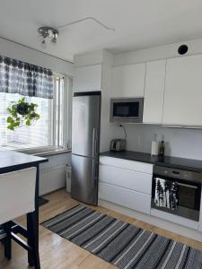 a kitchen with white cabinets and a stainless steel refrigerator at City center apartment in Rovaniemi