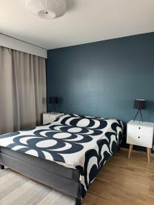 a bedroom with a black and white bed and blue walls at City center apartment in Rovaniemi