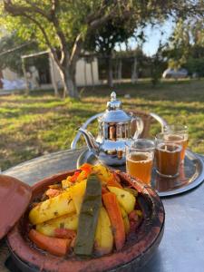 a plate of food on a table with a tea kettle at Appartements Armonía Sea View in Briech