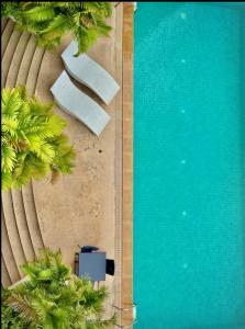 an overhead view of a swimming pool with palm trees at Cozy, Spacious 2-Bedder with City, Park View, Near Nana BTS in Bangkok