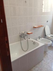 a bathroom with a bath tub and a toilet at PM 135 Corso Umberto Guest House in Cuglieri