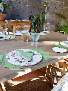 einem Holztisch mit Platten und einer Pflanze darauf in der Unterkunft Domus Florum Sorrento in Sorrent