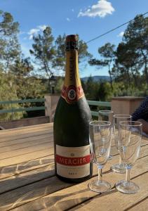 een fles wijn op een tafel met glazen bij Les Bosquets in Lorgues