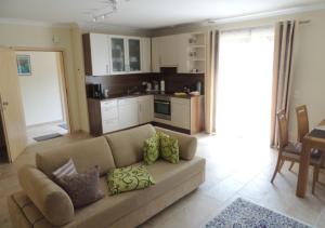 Una sala de estar con un sofá y una cocina. en Ferienwohnung am Rosengarten, en Füssen