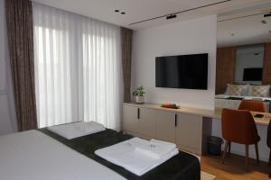 a hotel room with a bed and a desk with a television at Hotel Ari in Gjakove