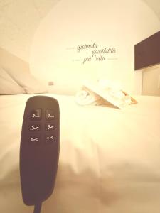 a black remote control sitting on top of a bed at Suite Salgemma in Polignano a Mare