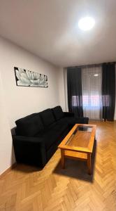 un soggiorno con un divano nero e un tavolino da caffè di Ávila Kat ad Ávila