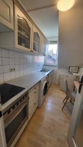 cocina con fogones, fregadero y lavavajillas en Apartments Sülmerstrasse, en Heilbronn