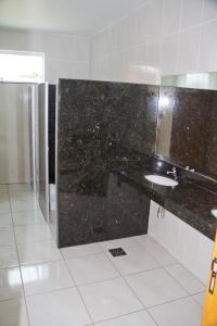 a bathroom with a black counter and a sink at HC Hotel Paraopeba in Paraopeba +34 photos