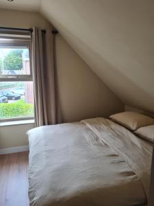 een bed in een kamer met een raam bij Tussen poort en toren in Sneek