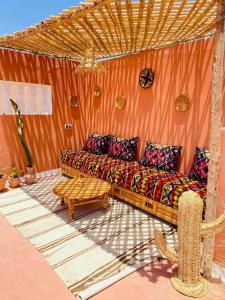 una sala de estar con un sofá y una mesa en Dar Minel- Deine Wohlfühloase mit Garten und Sonnenterasse, en Zaouit Massa