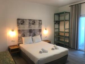 a bedroom with a bed with two towels on it at O Tourinho Ferrel in Ferrel