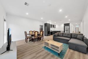 Wyndham ValeにあるWyndham Vale Retreat- Disability Friendly Accommodation- 4 Bedroom Holiday Homeのソファとテーブルのあるリビングルーム