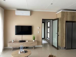 a living room with a flat screen tv on the wall at The Onyx Luxury Apartment in Windhoek